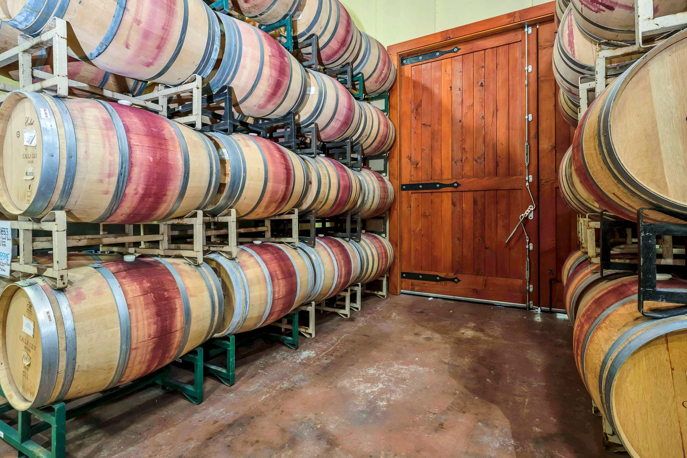 Barrels stacked in the Calla Lily cellar beside its timber door
