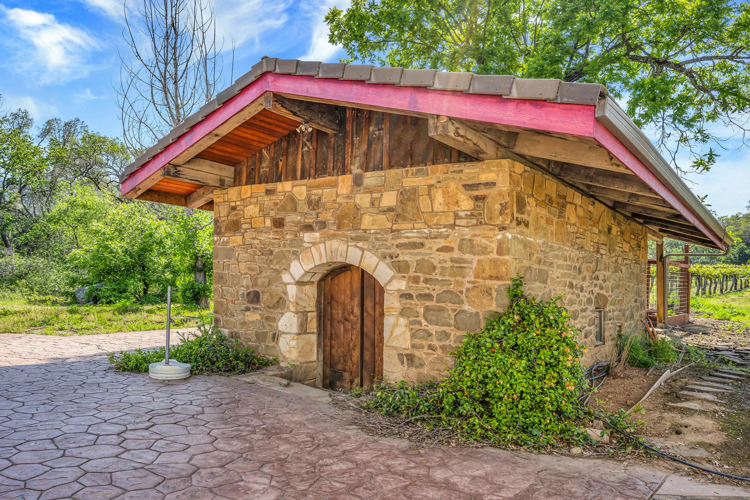 The estate's stone building, its arched timber door opening onto a flagstone terrace
